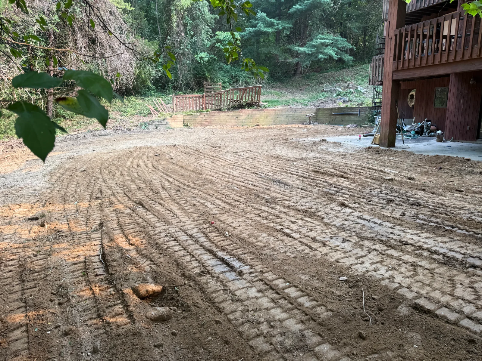 Compacted gravel driveway with tire tracks and prepared base material